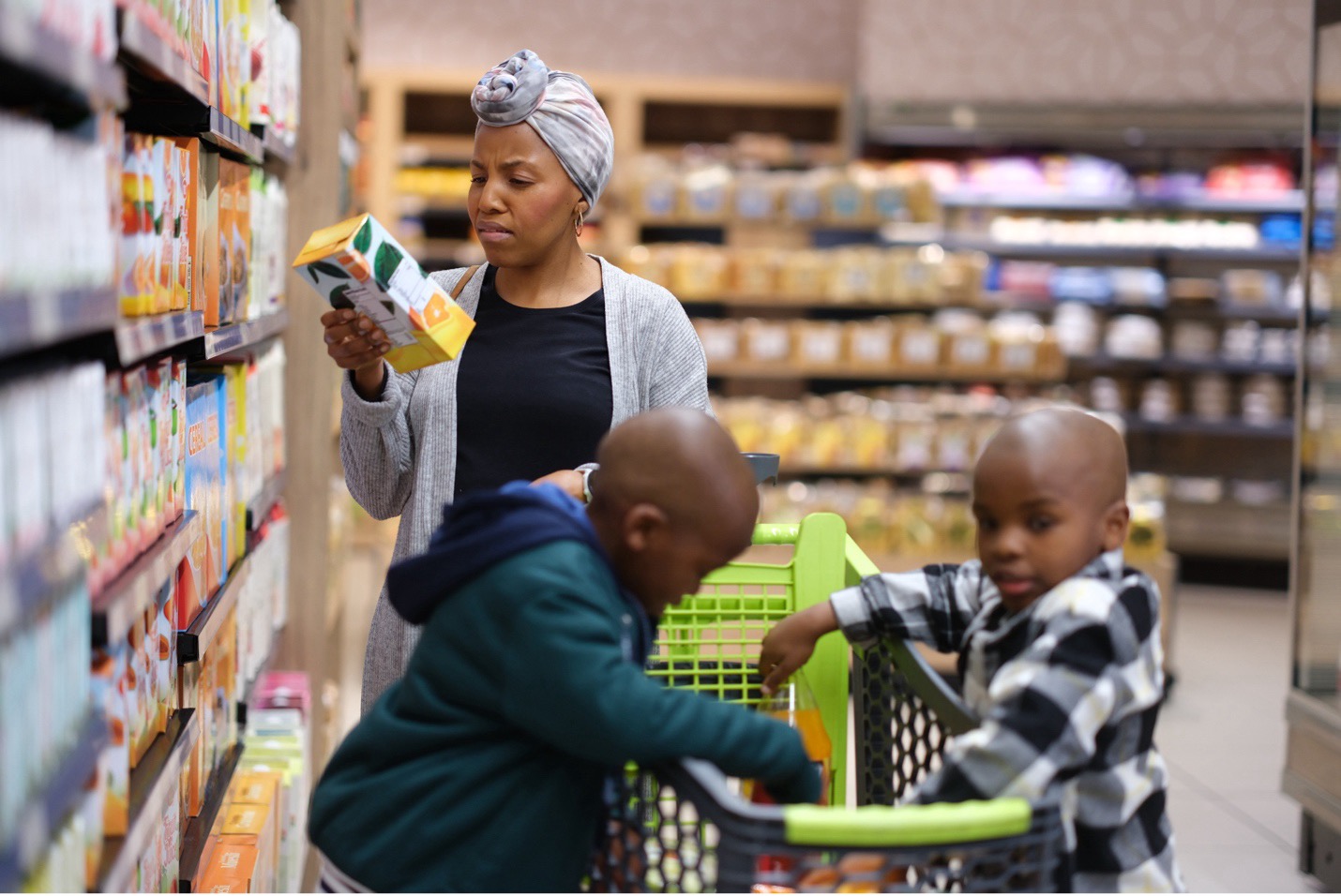 A woman assessing food options in a grocery store, including both healthy options and those that may contribute to diet-related chronic diseases.